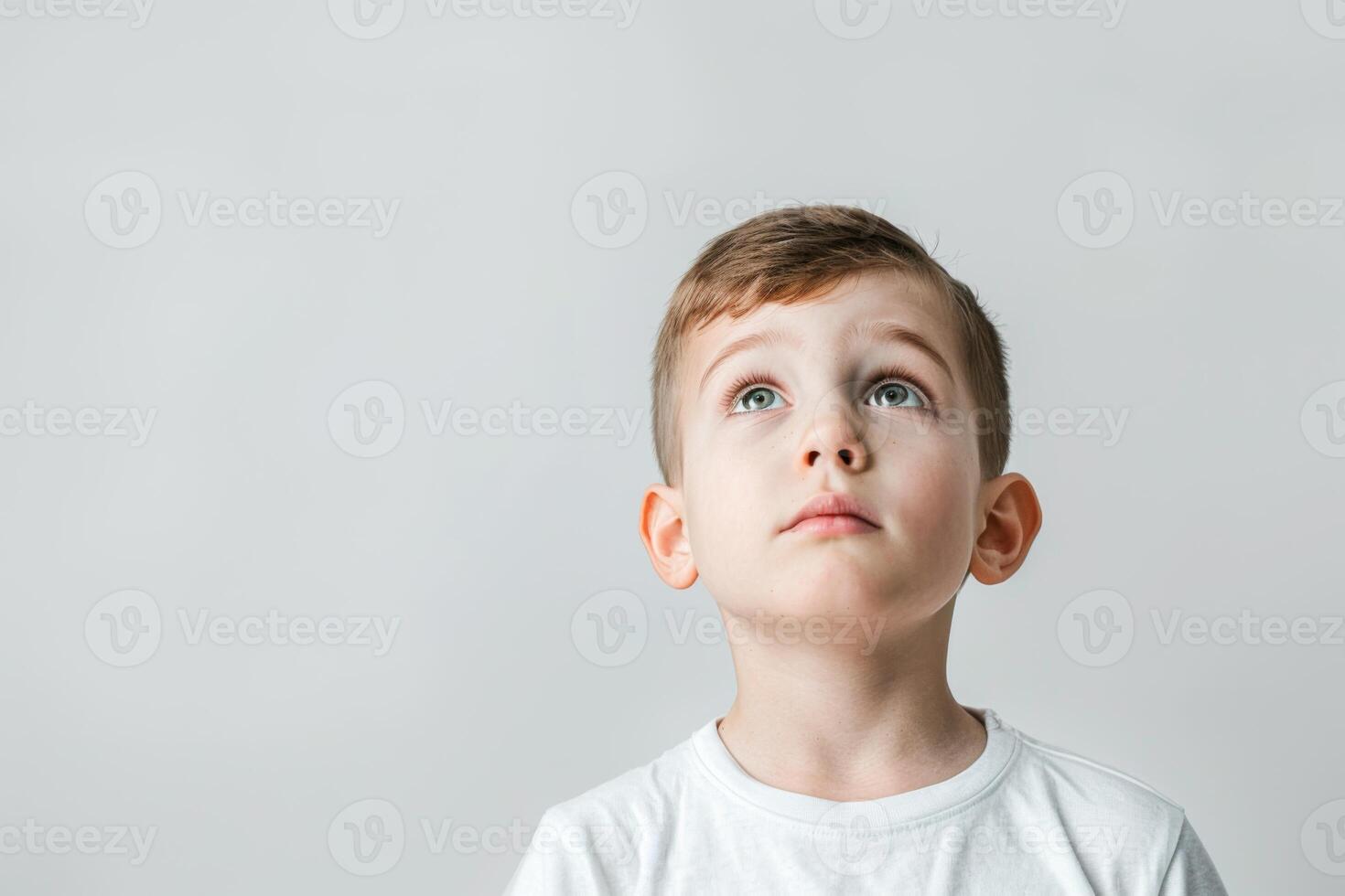 Young boy looking up with a hopeful expression on his face photo
