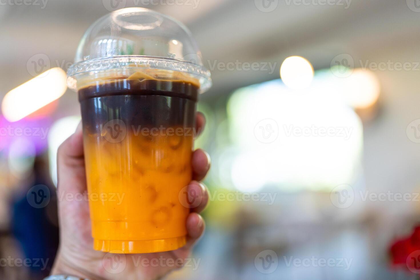 Iced coffee orange americano fusion with fresh orange juice mixed in a plastic cup photo