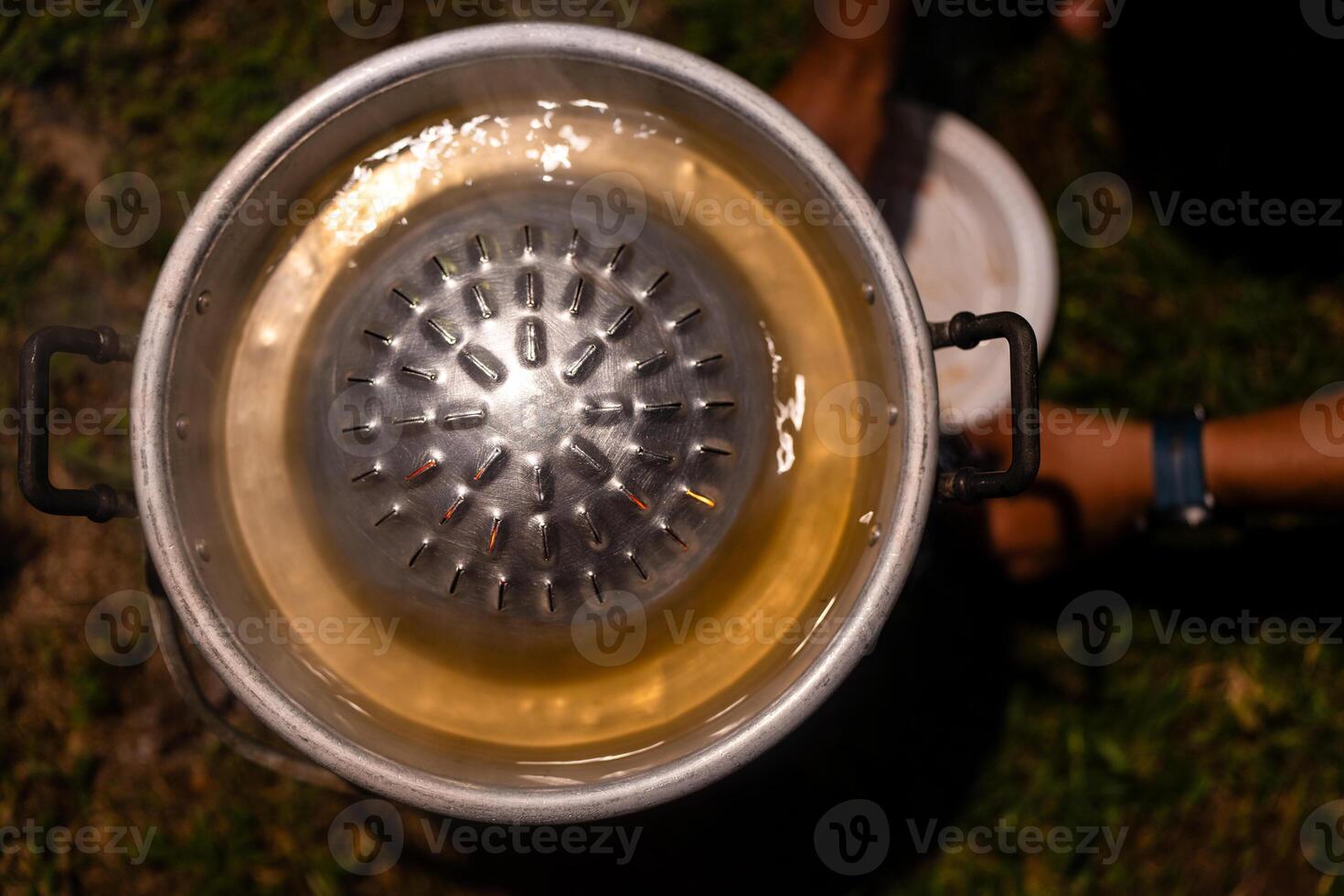 Empty metallic BBQ pan set on charcoal stove photo