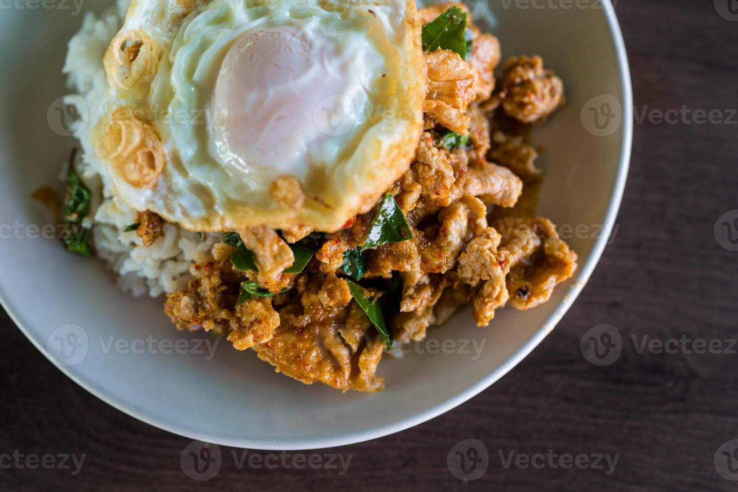 Stir fried pork with red curry paste and egg on rice photo