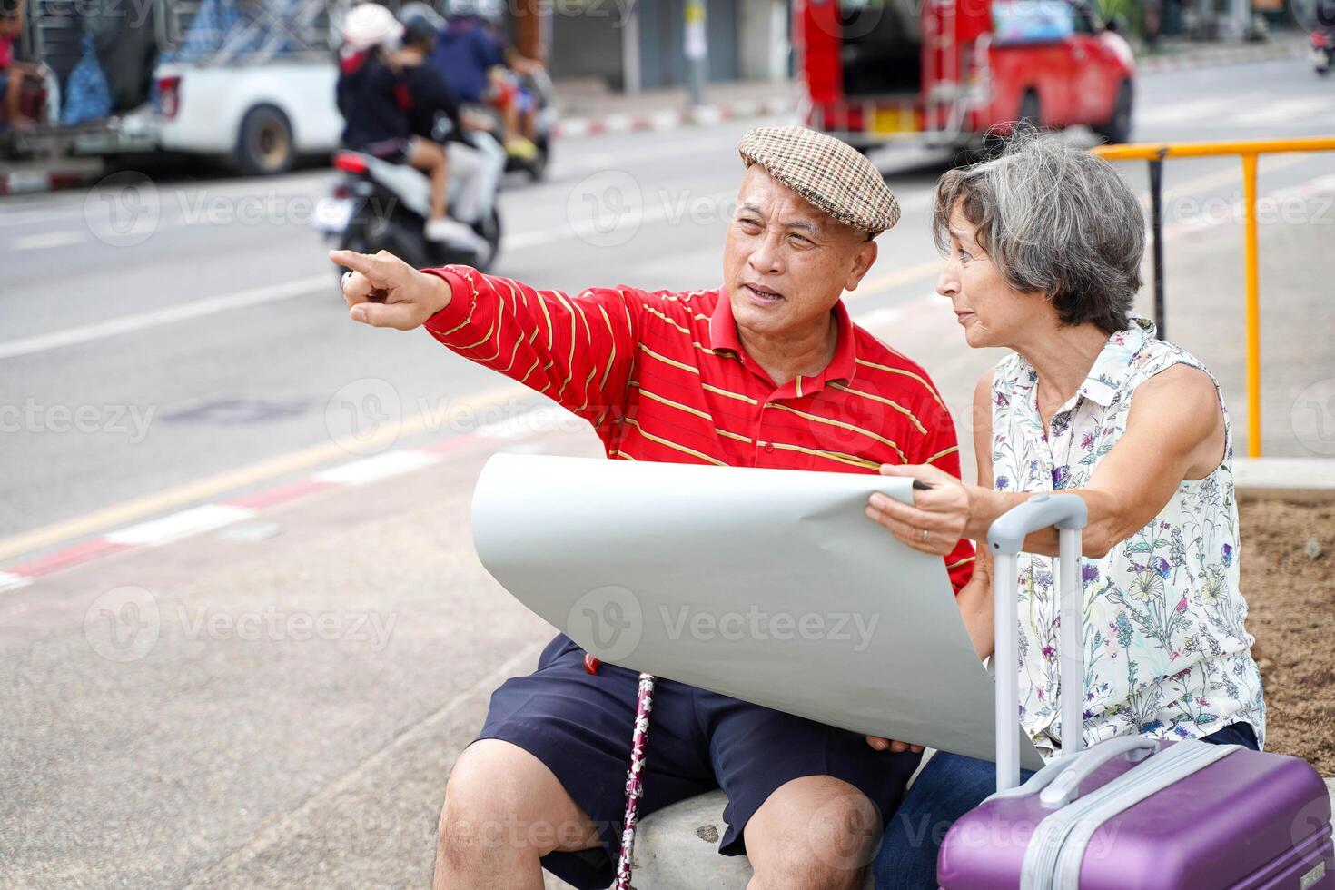A man points out the way to tourist attractions to senior female tourists on city background. Senior tourist concept photo