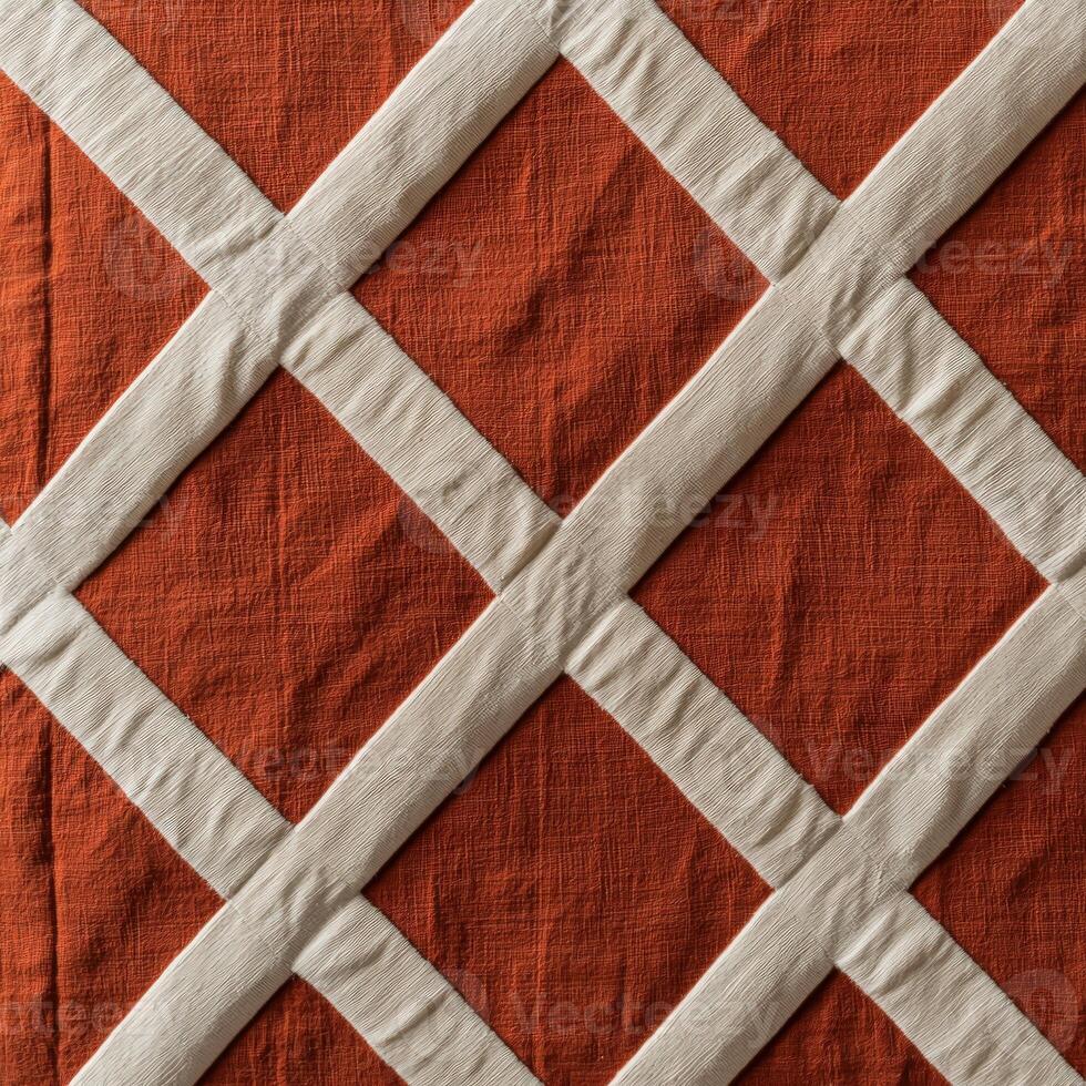 A quilted orange and white quilt with a diamond pattern photo