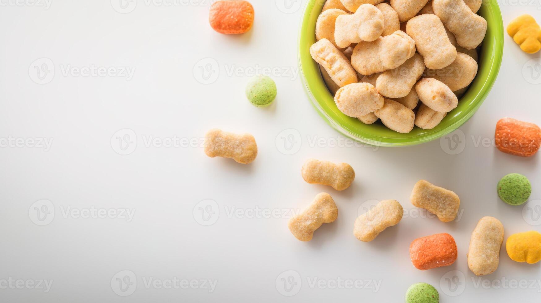 A bowl of dog treats on a white surface photo