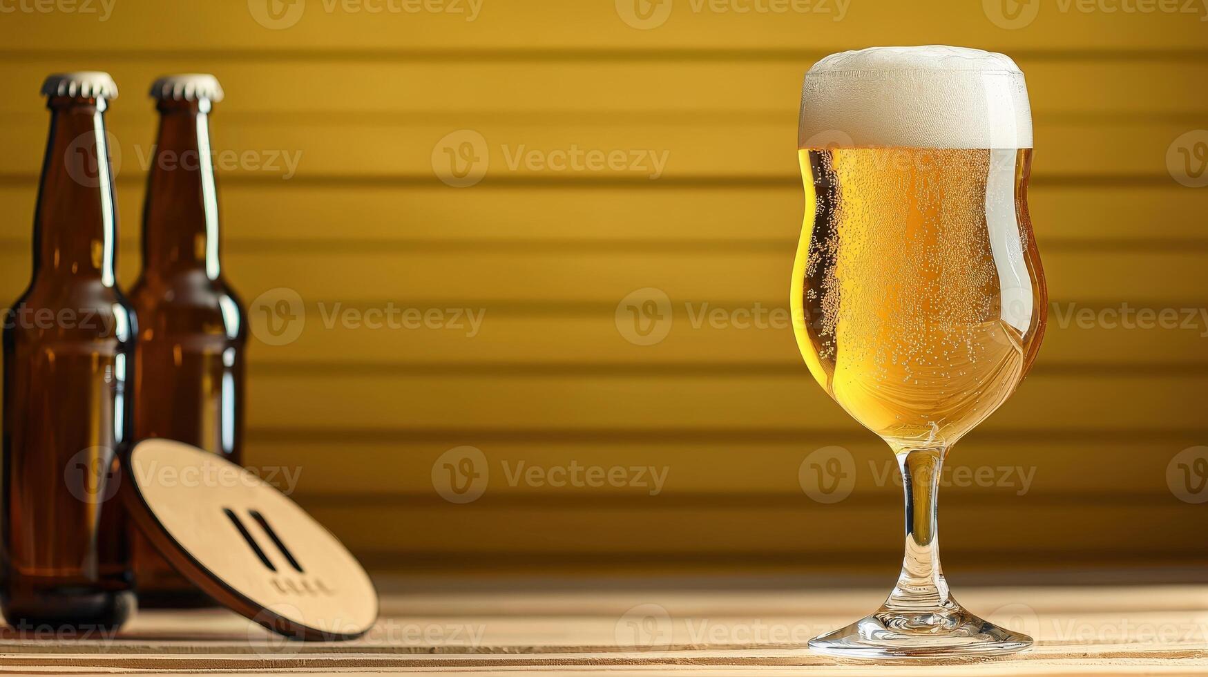 A glass of beer sitting on a table next to two bottles photo