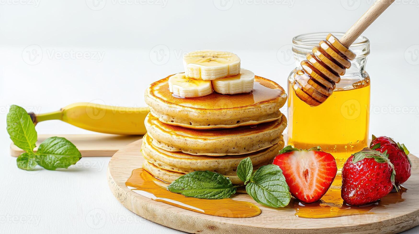Stack of pancakes with honey, banana and strawberries photo
