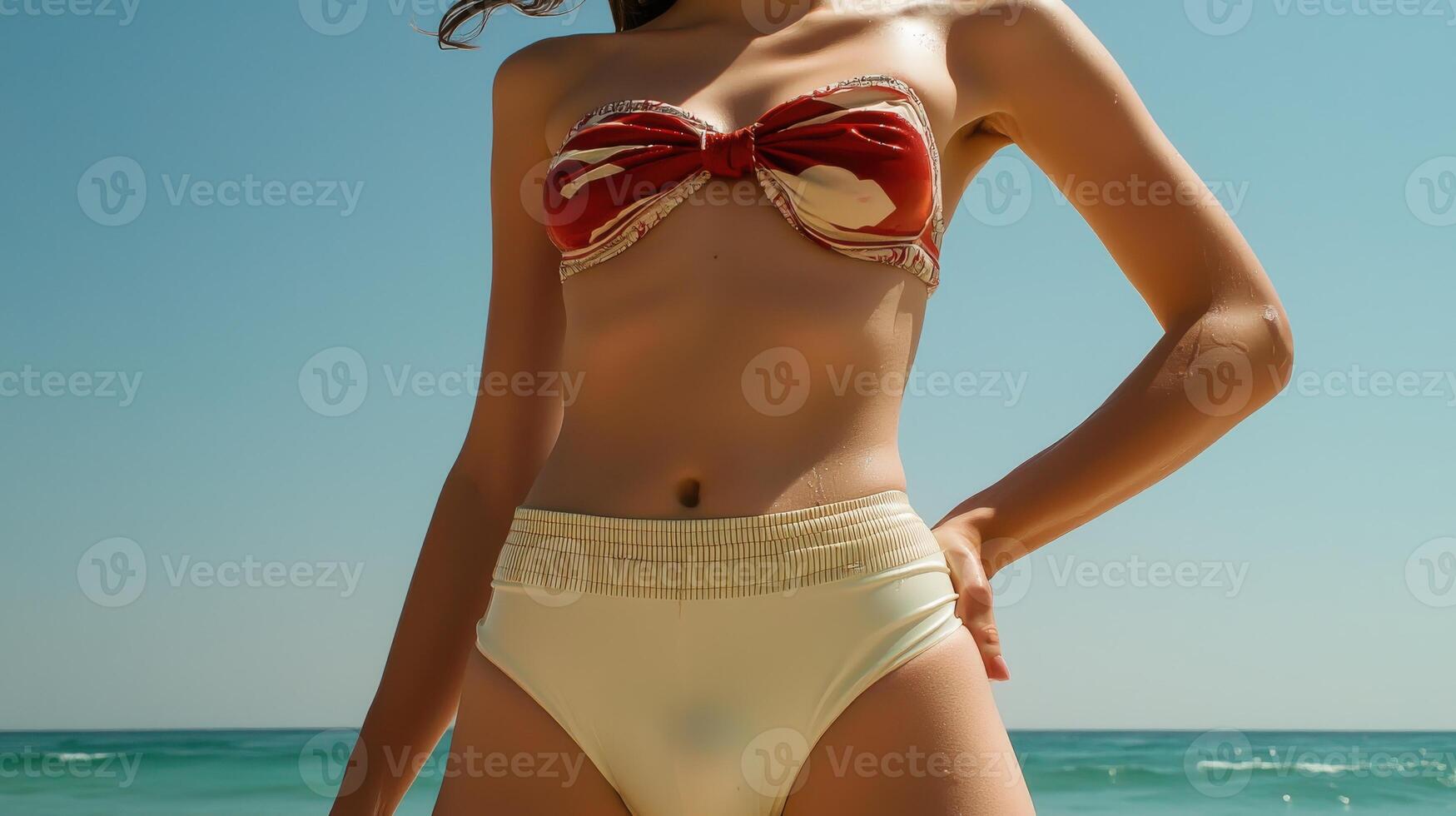 A woman in a bikini and white panties standing on the beach photo