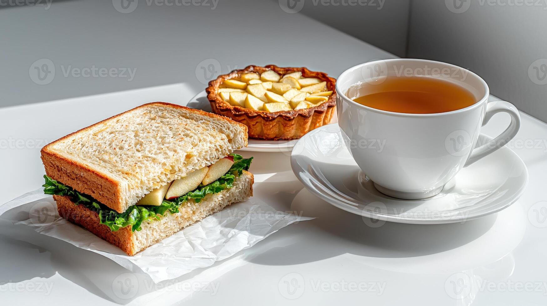 A sandwich and a cup of tea sit on a table photo