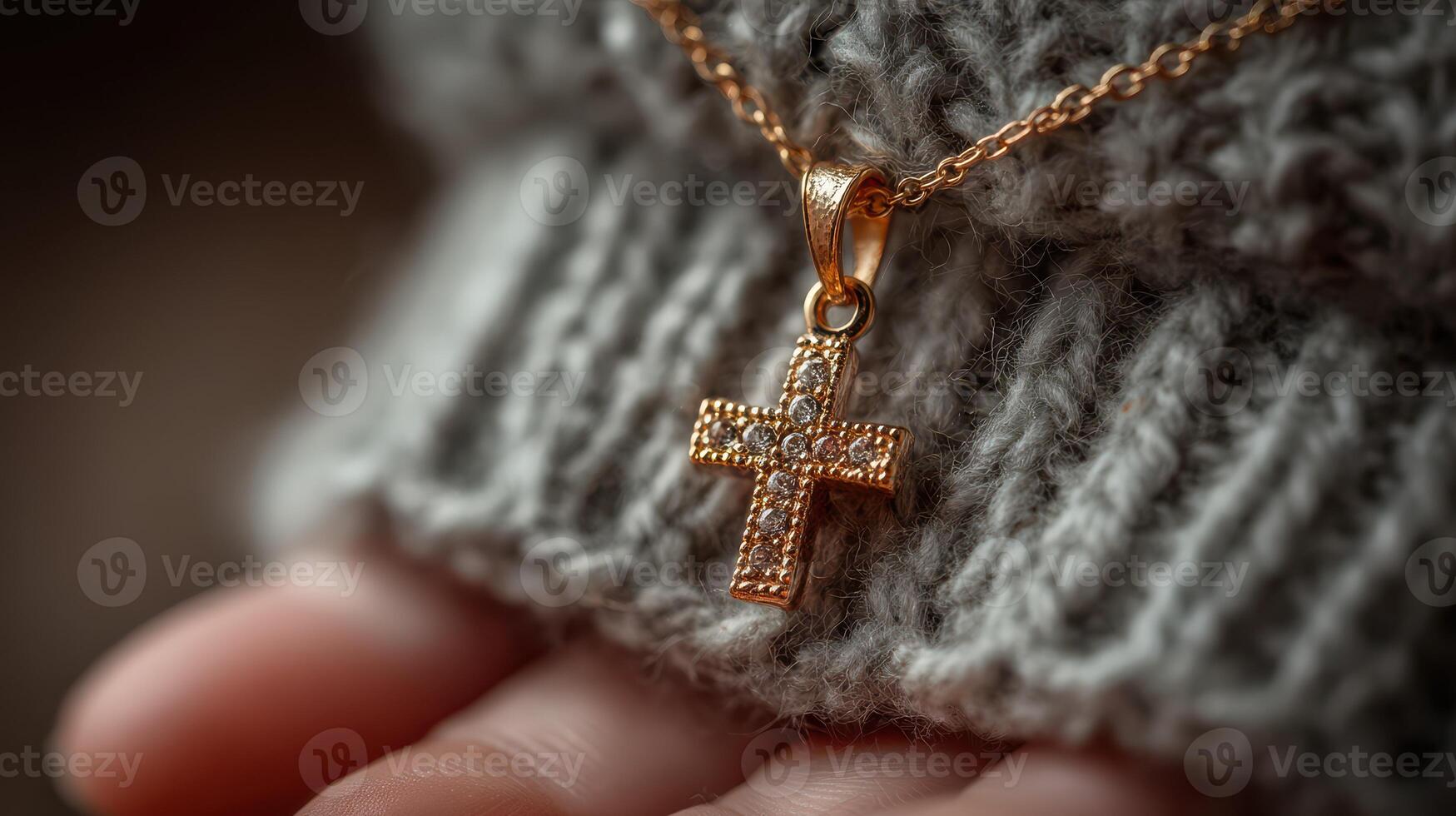 Elegant gold cross necklace reflects light while resting on a cozy knitted sweater during a winter afternoon photo