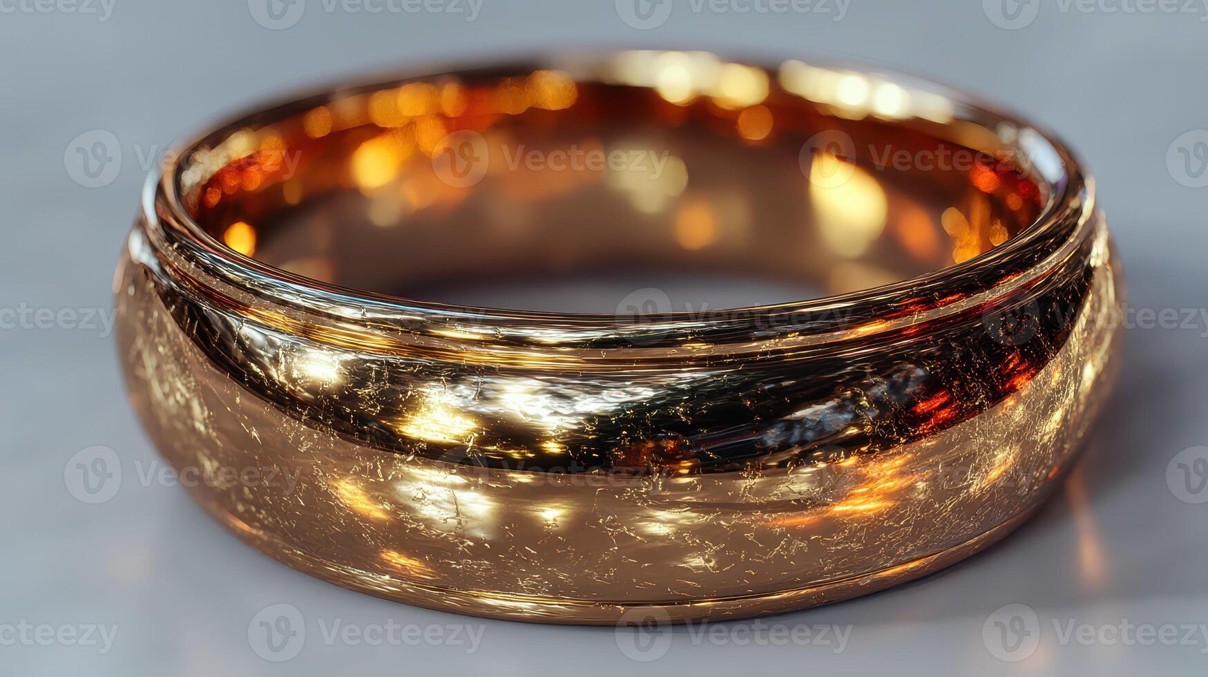 Elegant golden ring with intricate design displayed on smooth surface in well-lit setting photo