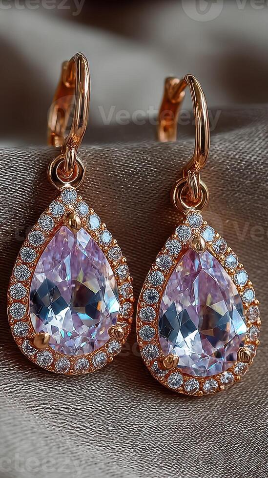 Elegant rose gold earrings with pear-shaped gemstones and sparkling accents displayed on a soft fabric background photo