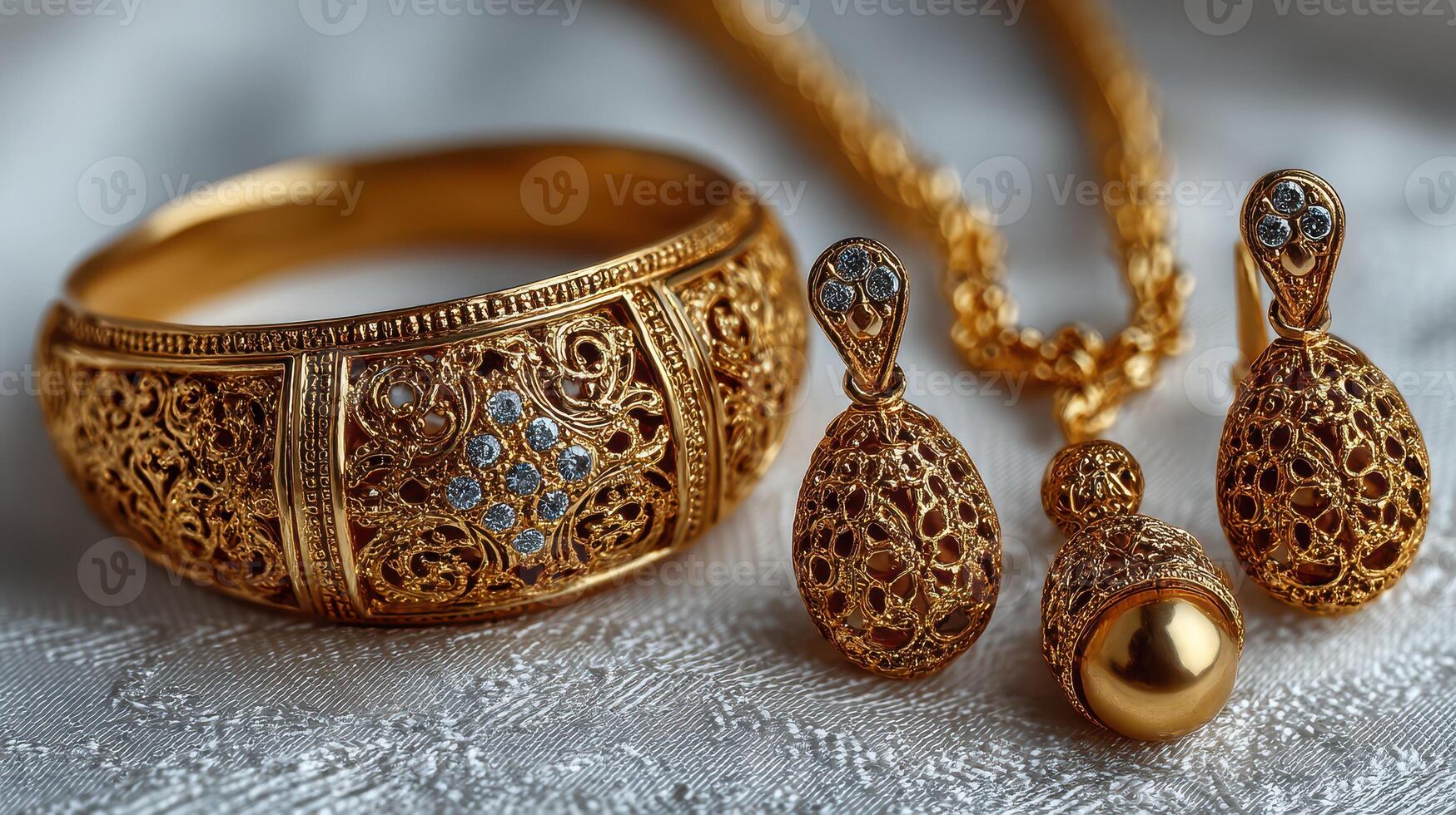 Elegant gold jewelry set displayed on delicate fabric with intricate designs and sparkling details, showcasing craftsmanship and artistry photo