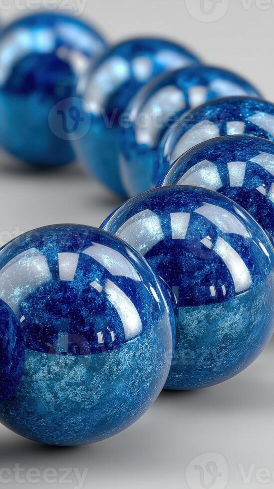 Bright blue decorative spheres displayed in a row on a smooth surface with elegant reflections and unique textures photo