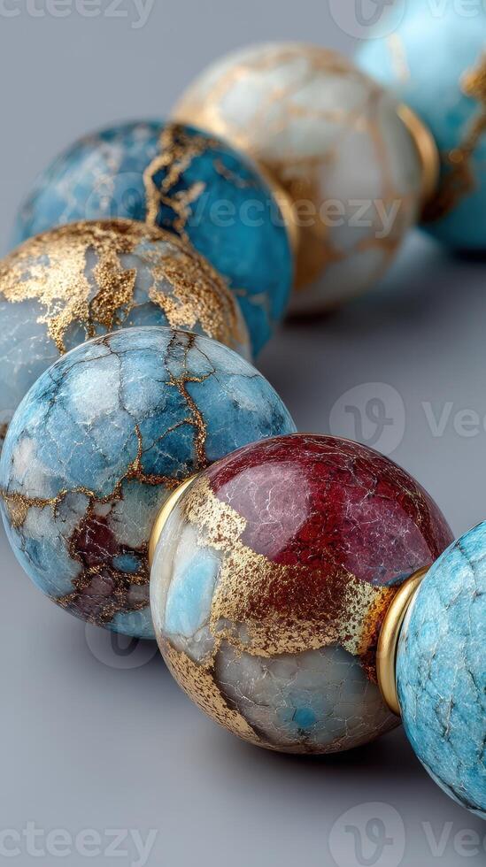 Colorful gemstone beads with intricate designs displayed against a neutral backdrop in a close-up view photo
