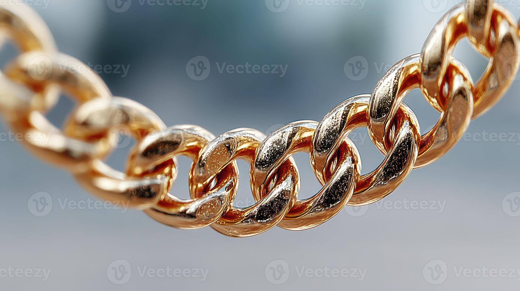 Close-up view of a shiny gold chain featuring intricate links on display in a bright outdoor setting during daylight photo