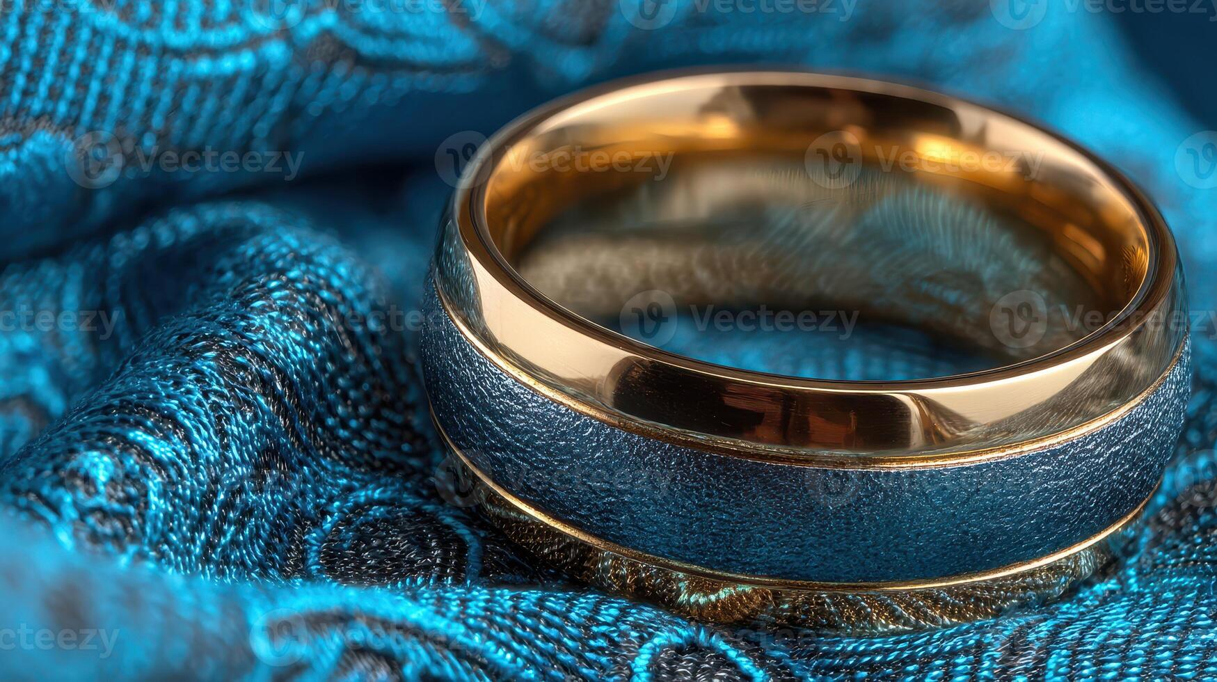 Elegant wedding ring rests on luxurious blue fabric, showcasing intricate design and craftsmanship in a close-up shot photo