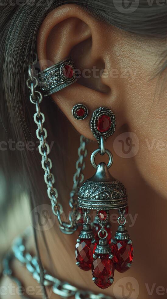 Intricate silver jewelry featuring red gemstones adorned on a model's ear during a fashion showcase in the afternoon light photo