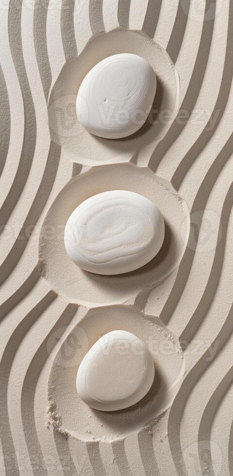 Three white rocks are placed in a sand-like setting photo