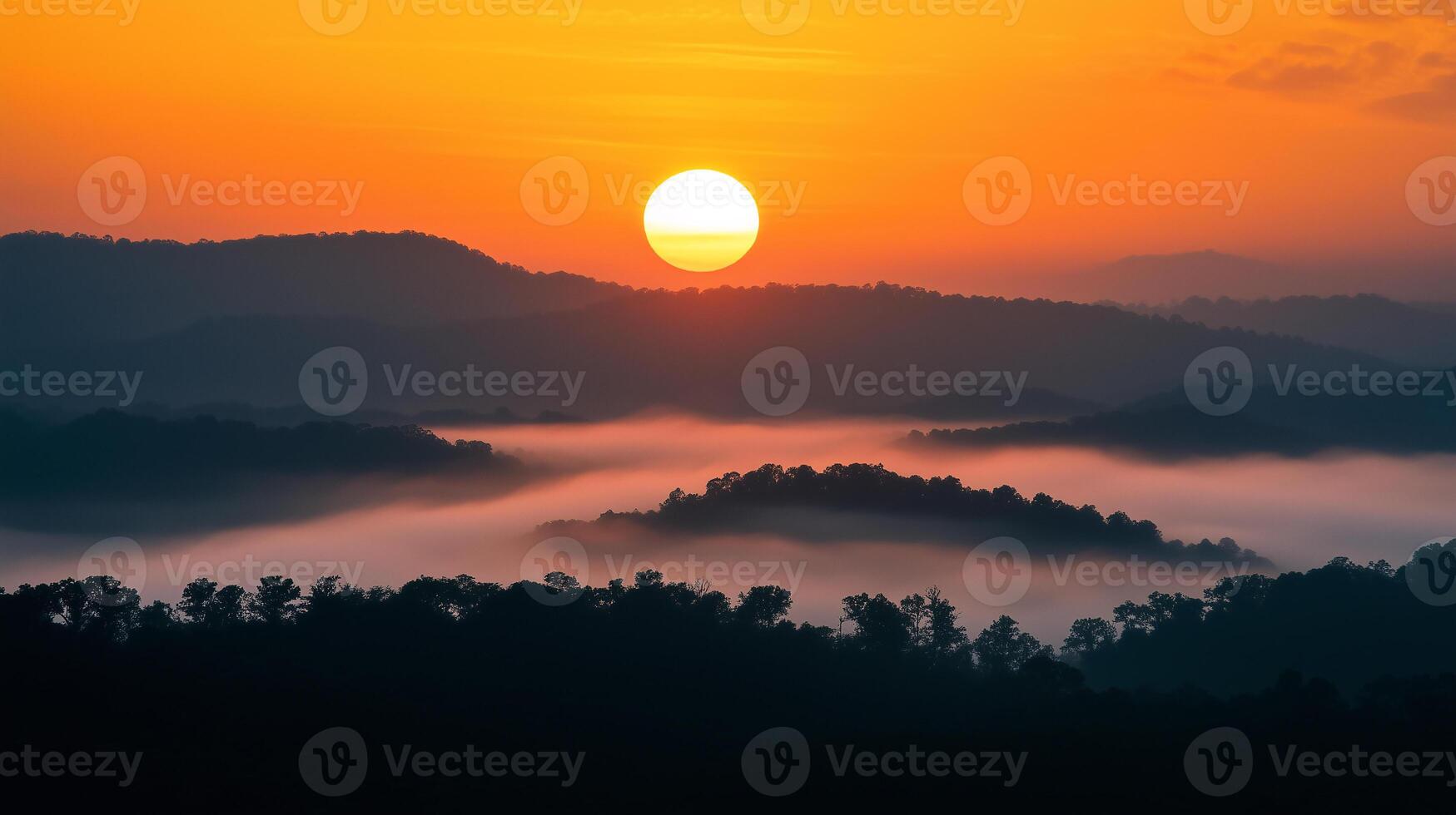 The sun is setting over a mountain range, casting a warm glow over the landscape photo