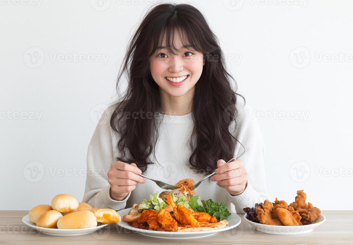 A woman is eating a meal with a variety of foods on her plate photo