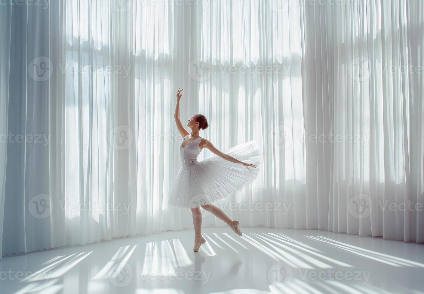 A graceful ballerina dances in a sunlit studio surrounded by flowing white curtains during a serene afternoon performance photo