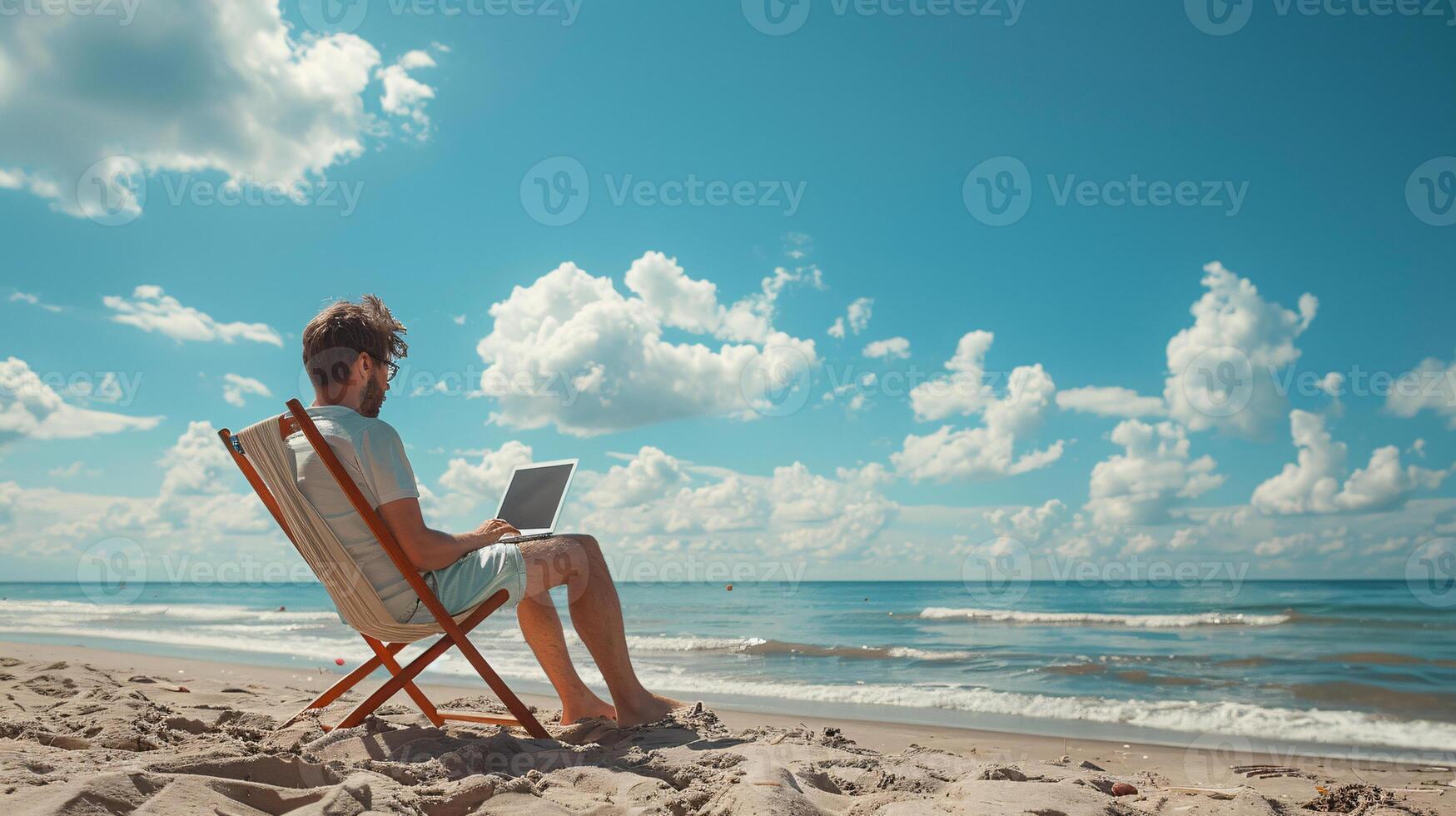 A man is sitting on a beach chair with a laptop in front of him and beautiful sky photo