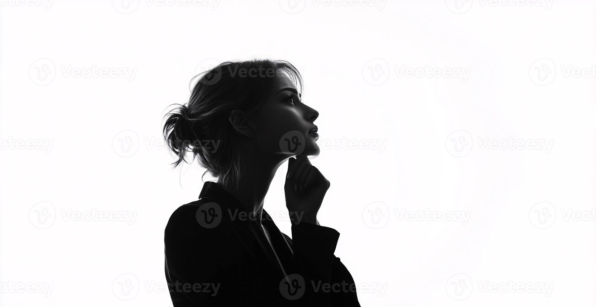 A woman is standing in front of a white background, looking to the right photo