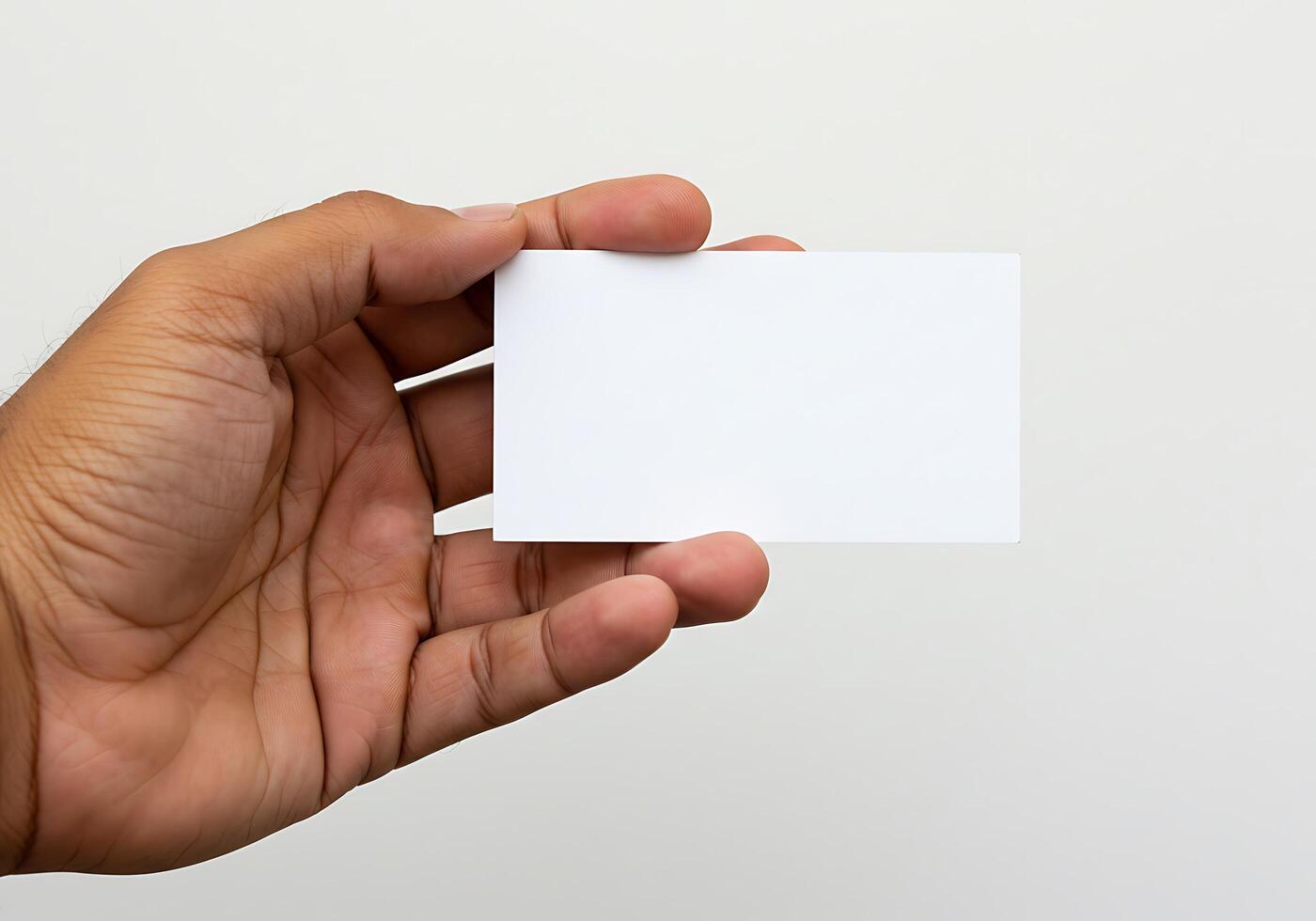 A hand holding a blank business card on a white background photo