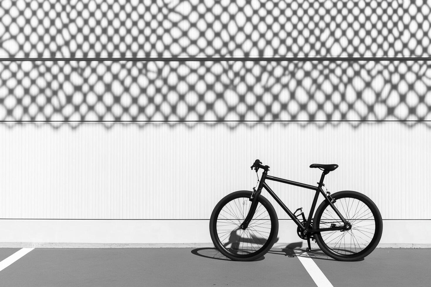 A black and white photo of a bike parked in a parking lot