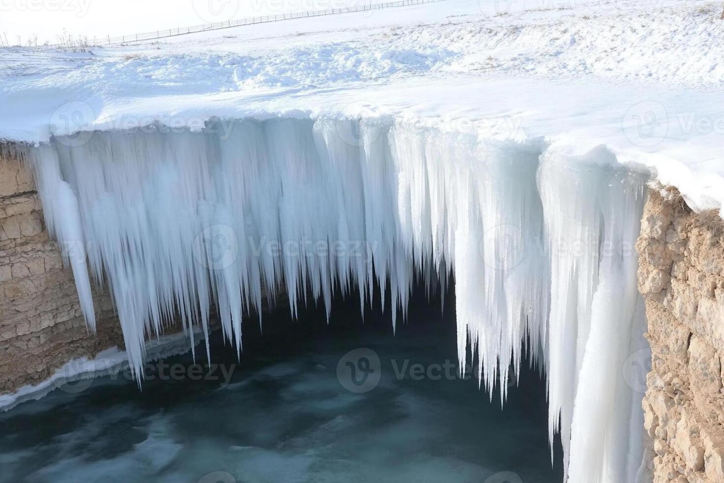A frozen waterfall is seen in the middle of a lake photo
