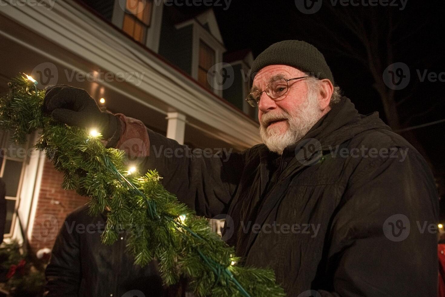A man holding a christmas wreath in front of a house photo