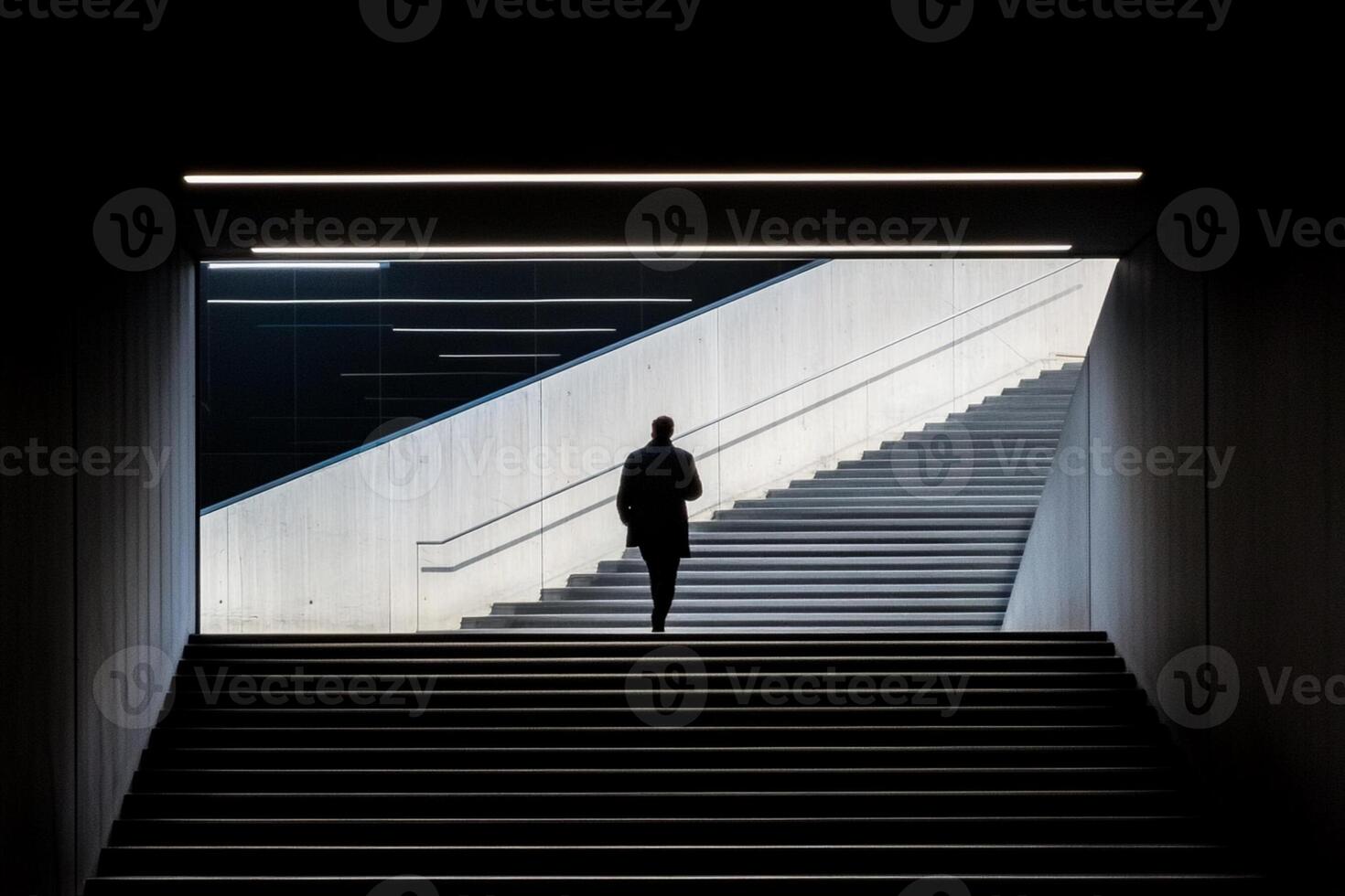 A person walking down a set of stairs in a dark room photo