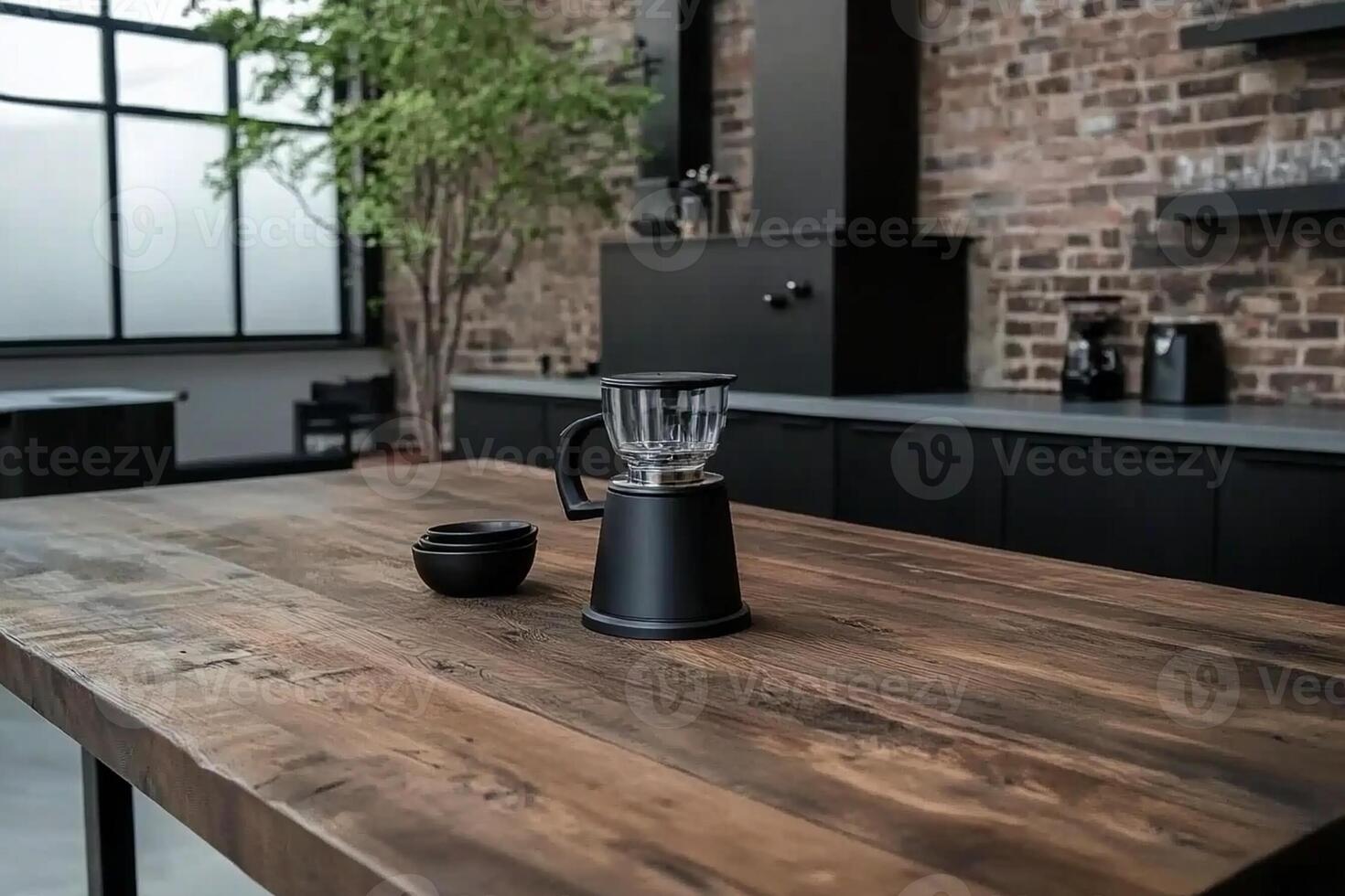 A black coffee maker on a wooden table in a kitchen photo