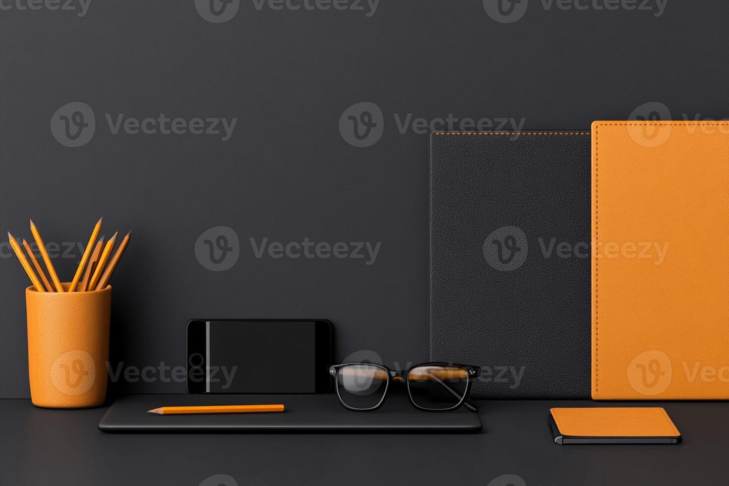 An orange notebook, pen, glasses and other items on a desk photo