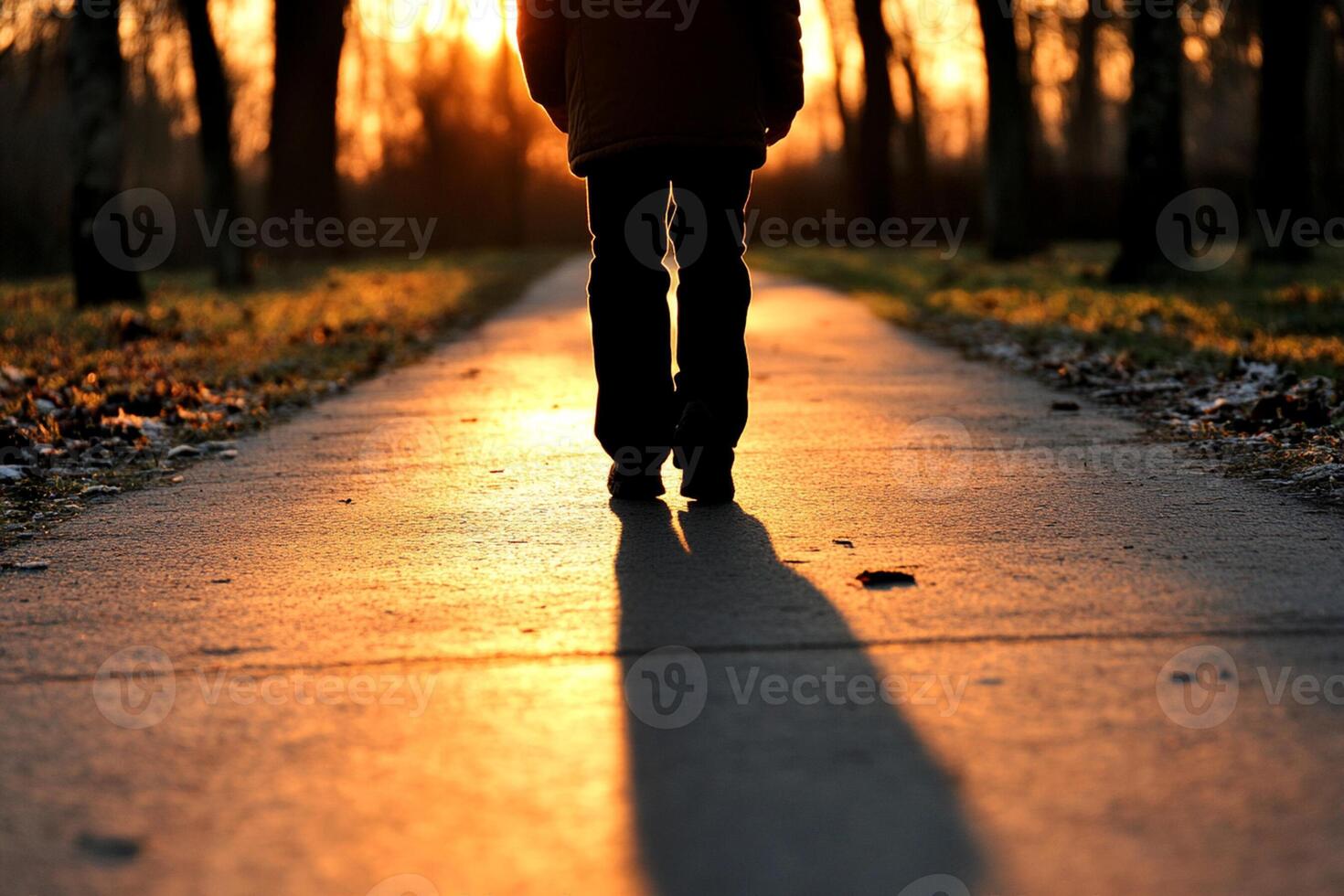 A person walking down a path at sunset photo