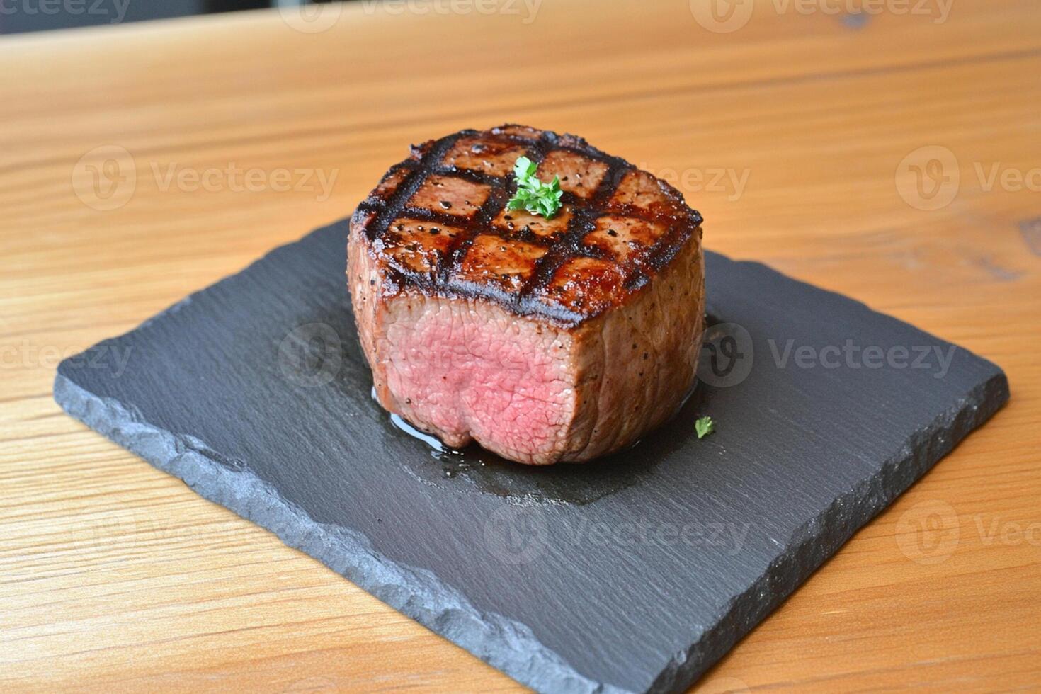 A steak sitting on a black slate plate photo