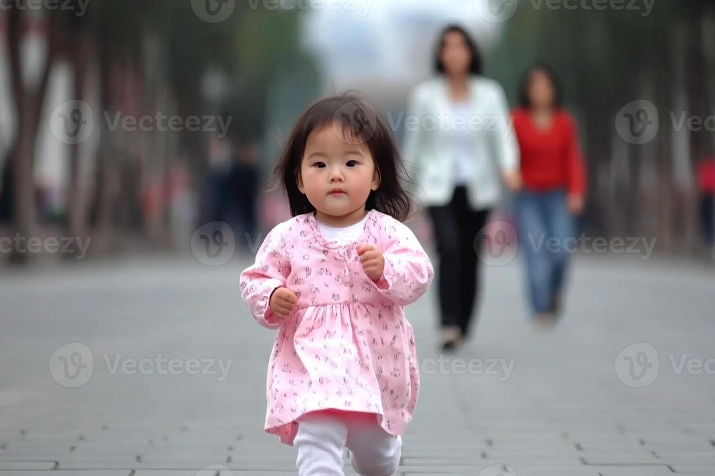 A little girl running on a sidewalk with people in the background photo