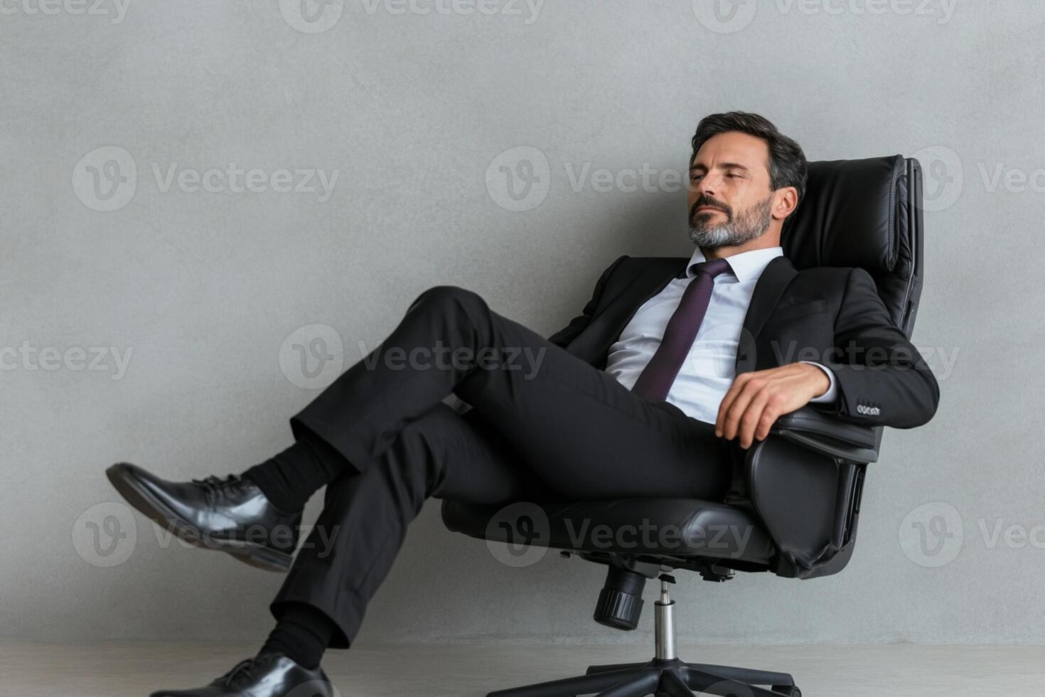 A man in a suit and tie sitting on an office chair photo