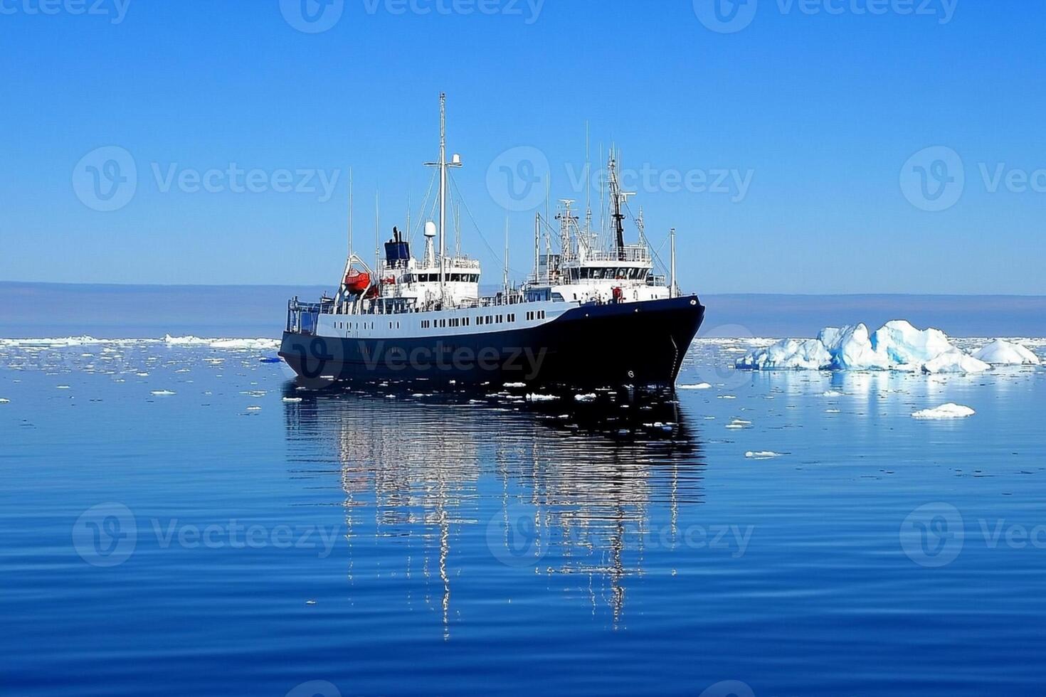 A large boat floating in the ocean near icebergs photo