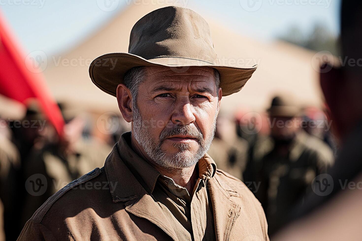 A man in a hat and uniform standing in front of a crowd photo