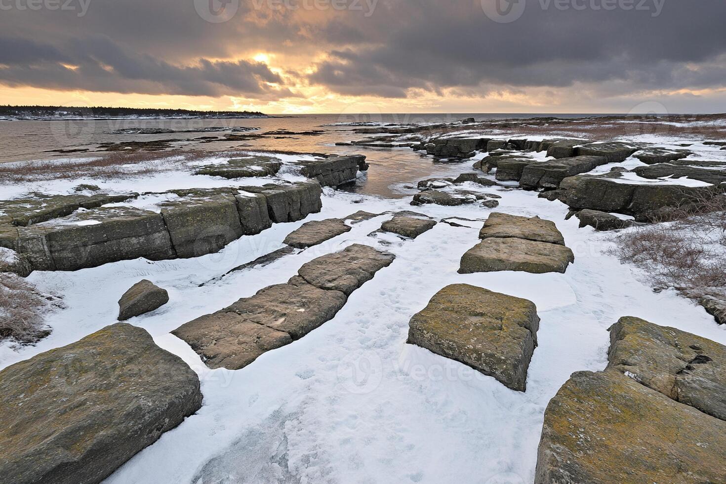 A view of the ocean and rocks covered in snow photo