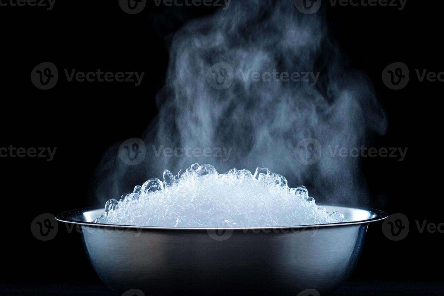 A bowl of ice is being heated in the dark photo