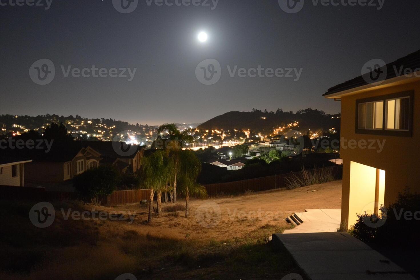 A full moon shines over a house at night photo