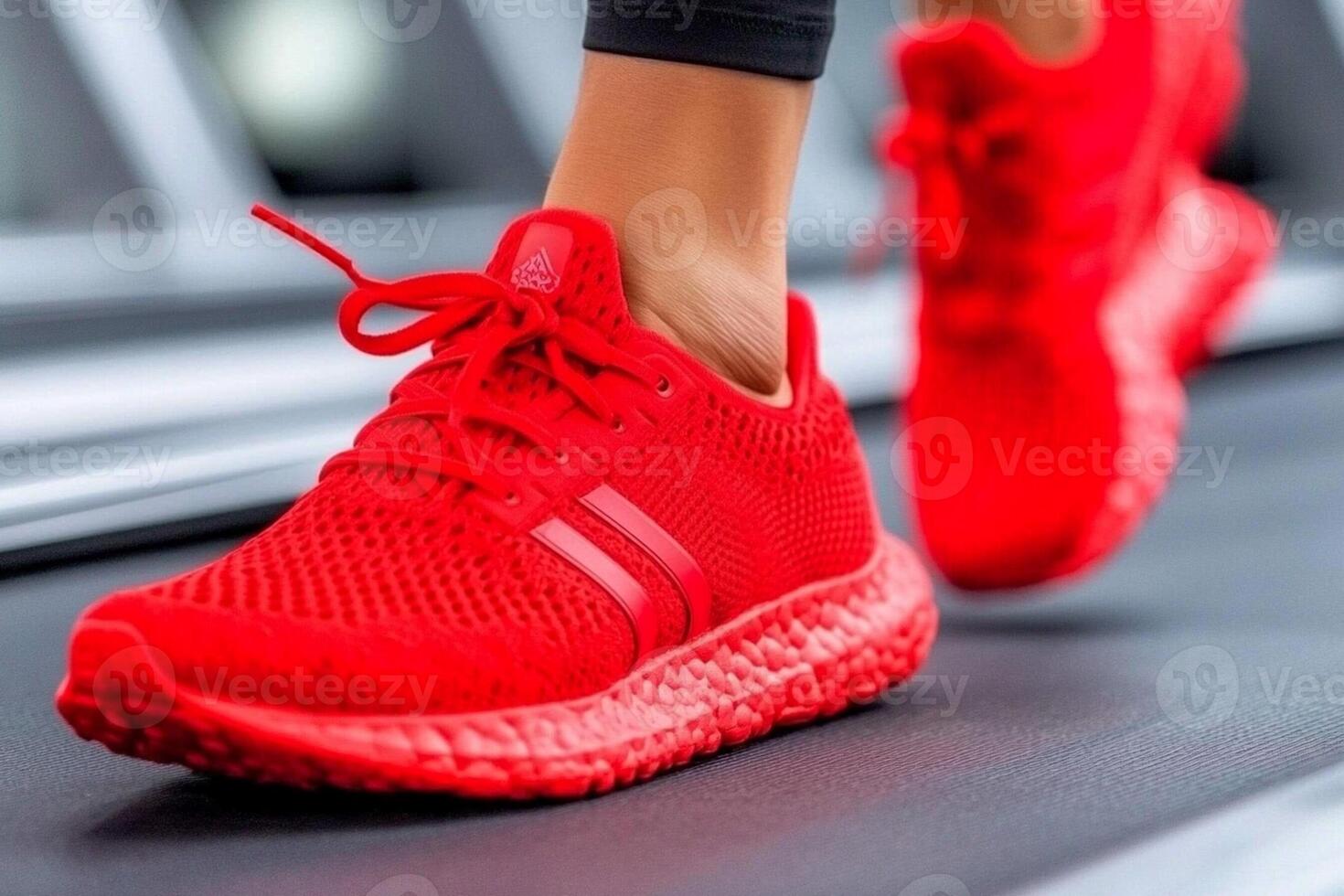 A woman wearing red running shoes on a treadmill photo