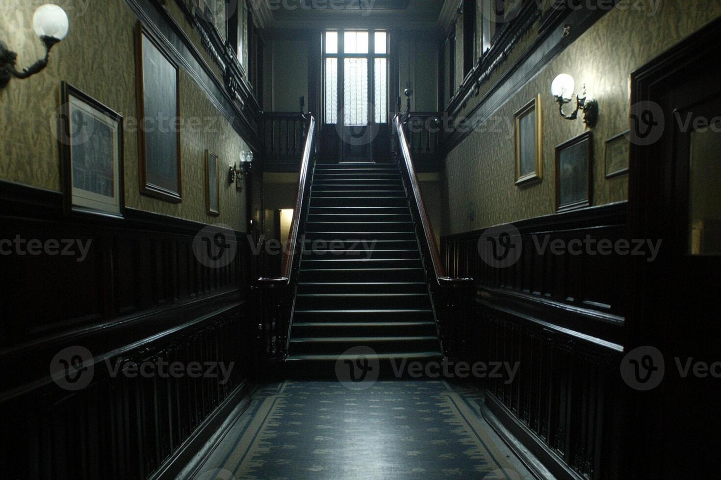 A dark hallway with a staircase and a light at the top photo