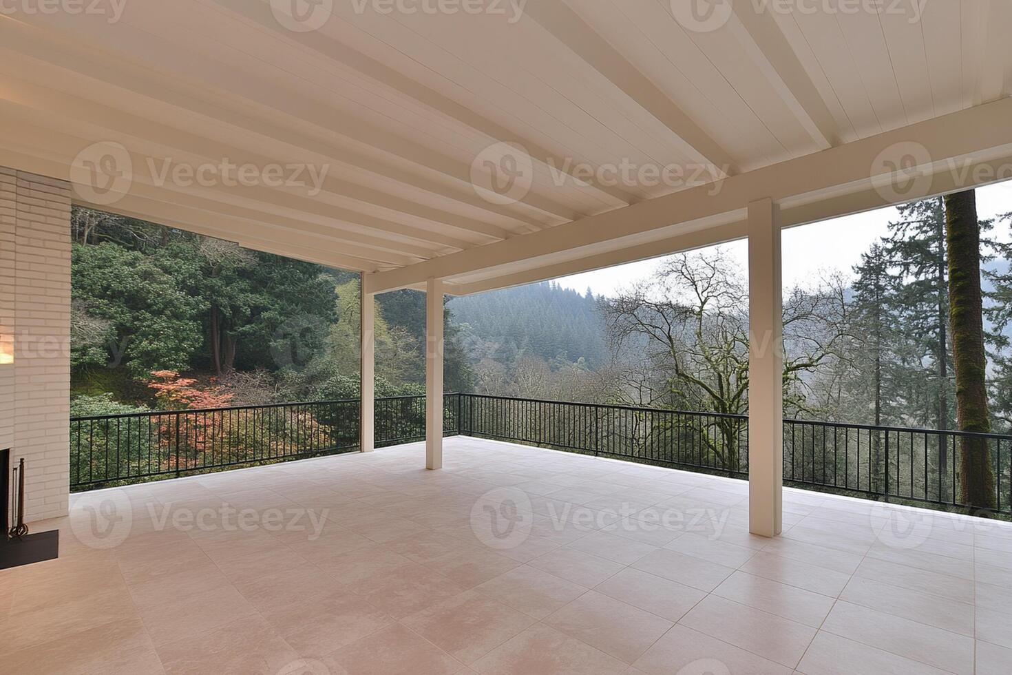 A large porch with a fireplace and a view of the forest photo