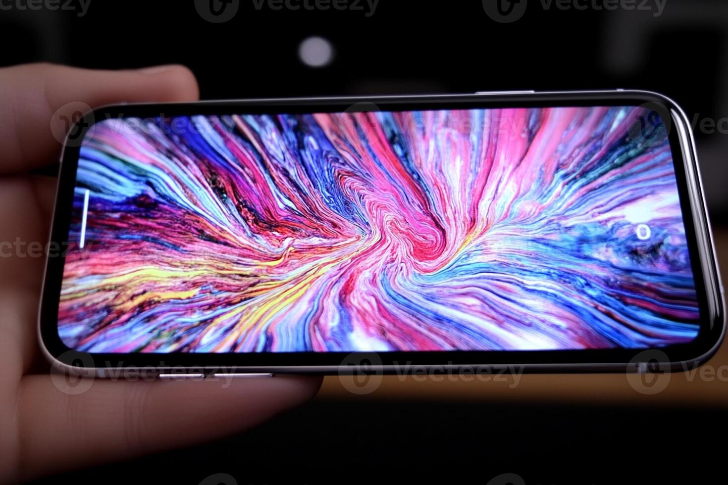 A person holding an iphone with a colorful swirl on the screen photo