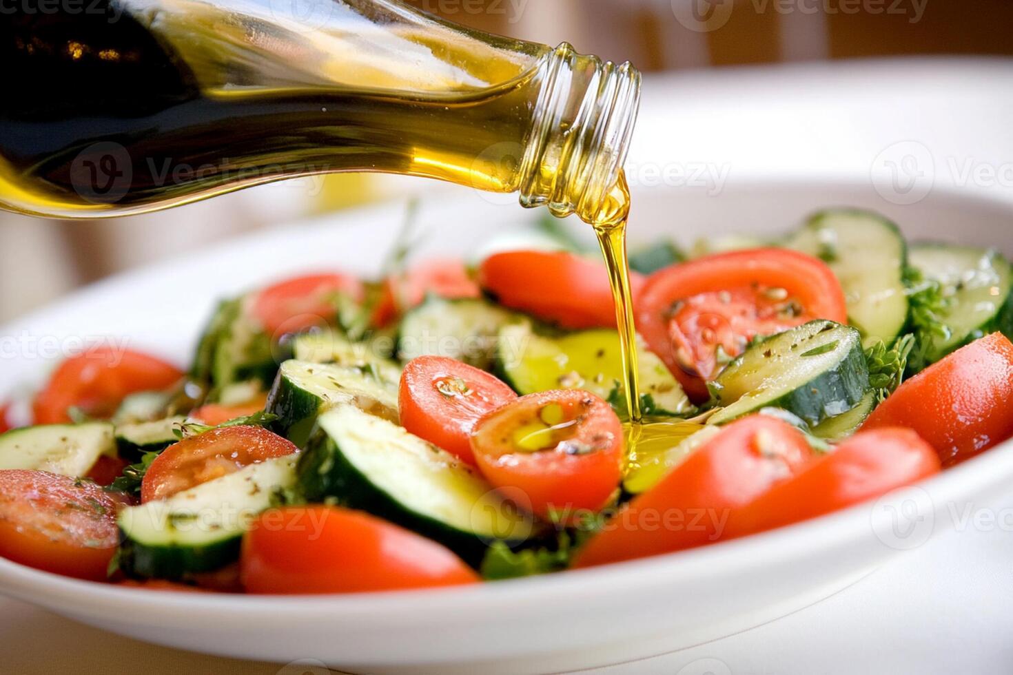 A bowl of salad with tomatoes, cucumbers, and olive oil photo