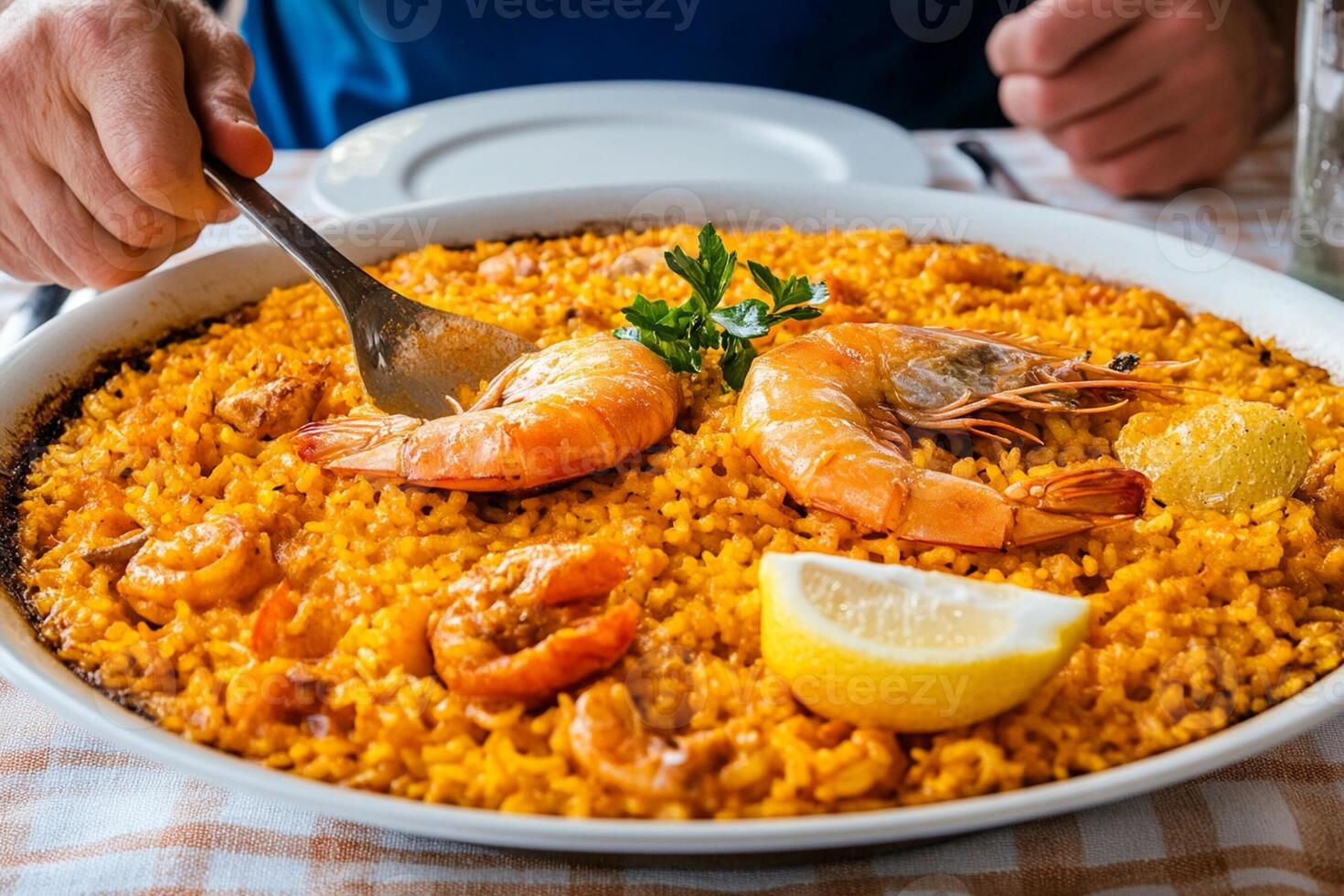 A plate of paella with shrimp and lemon photo