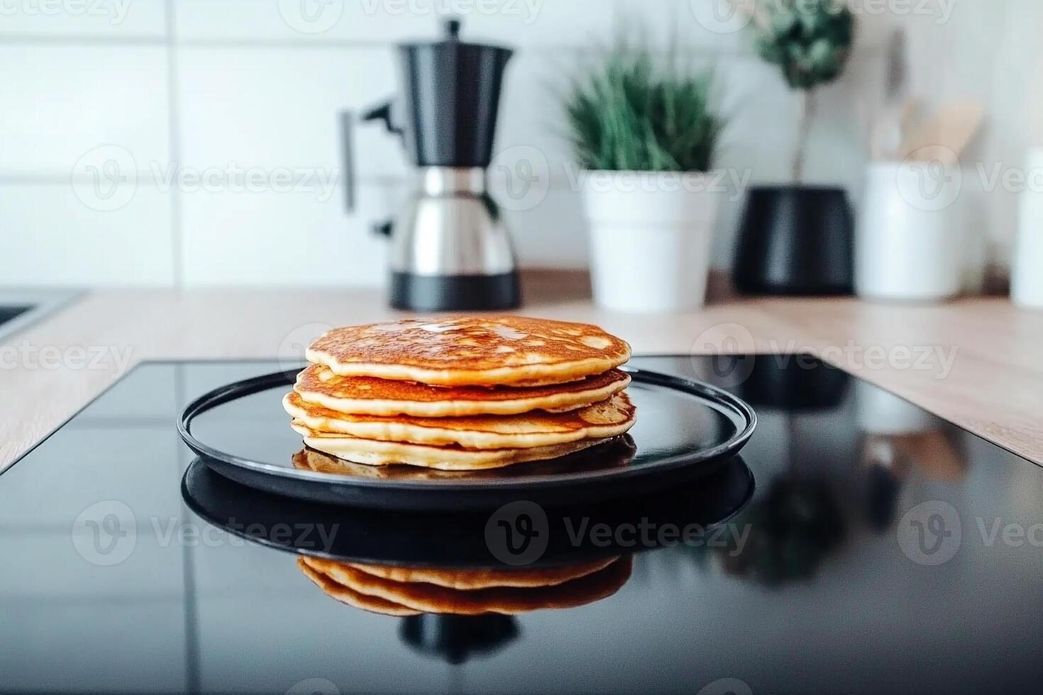 Stack of pancakes on a black plate on a kitchen counter photo