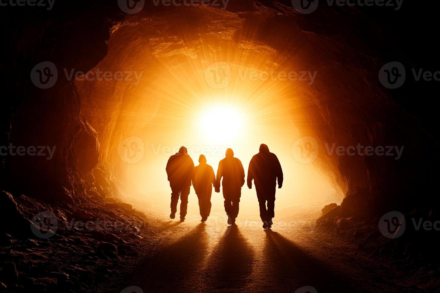 People walking through a tunnel with the sun shining through photo